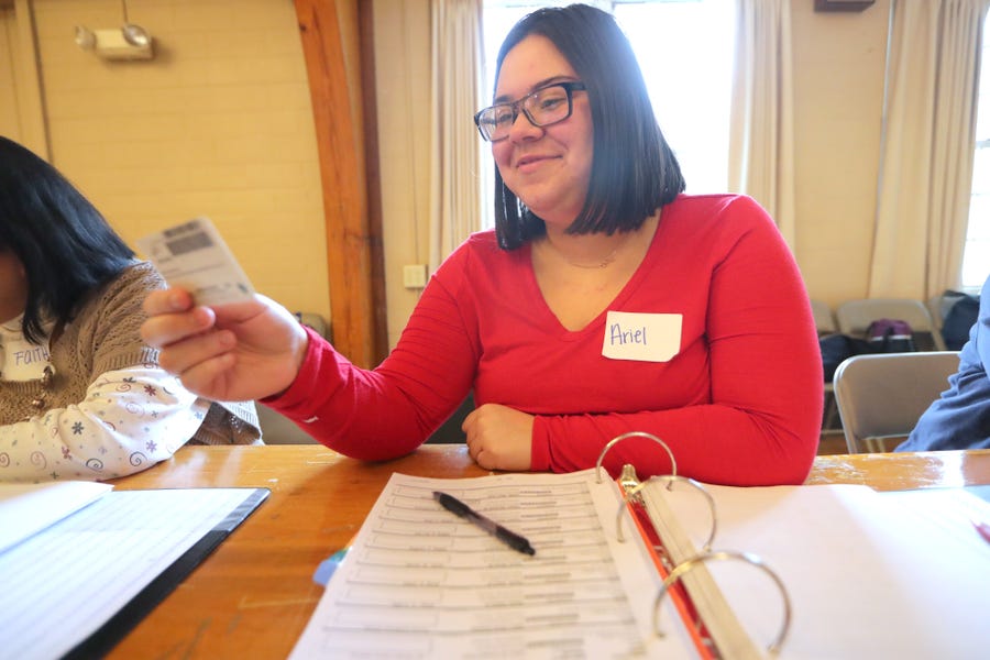 Poll worker Ariel Dashner checks a voter's ID at the Hart Park?Muellner?Building in Wauwatosa.