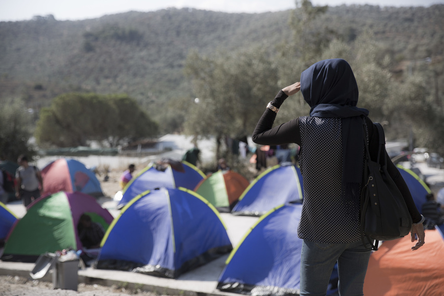 A woman looks out over tents being used by migrants and asylum seekers on the Greek island of Lesvos.