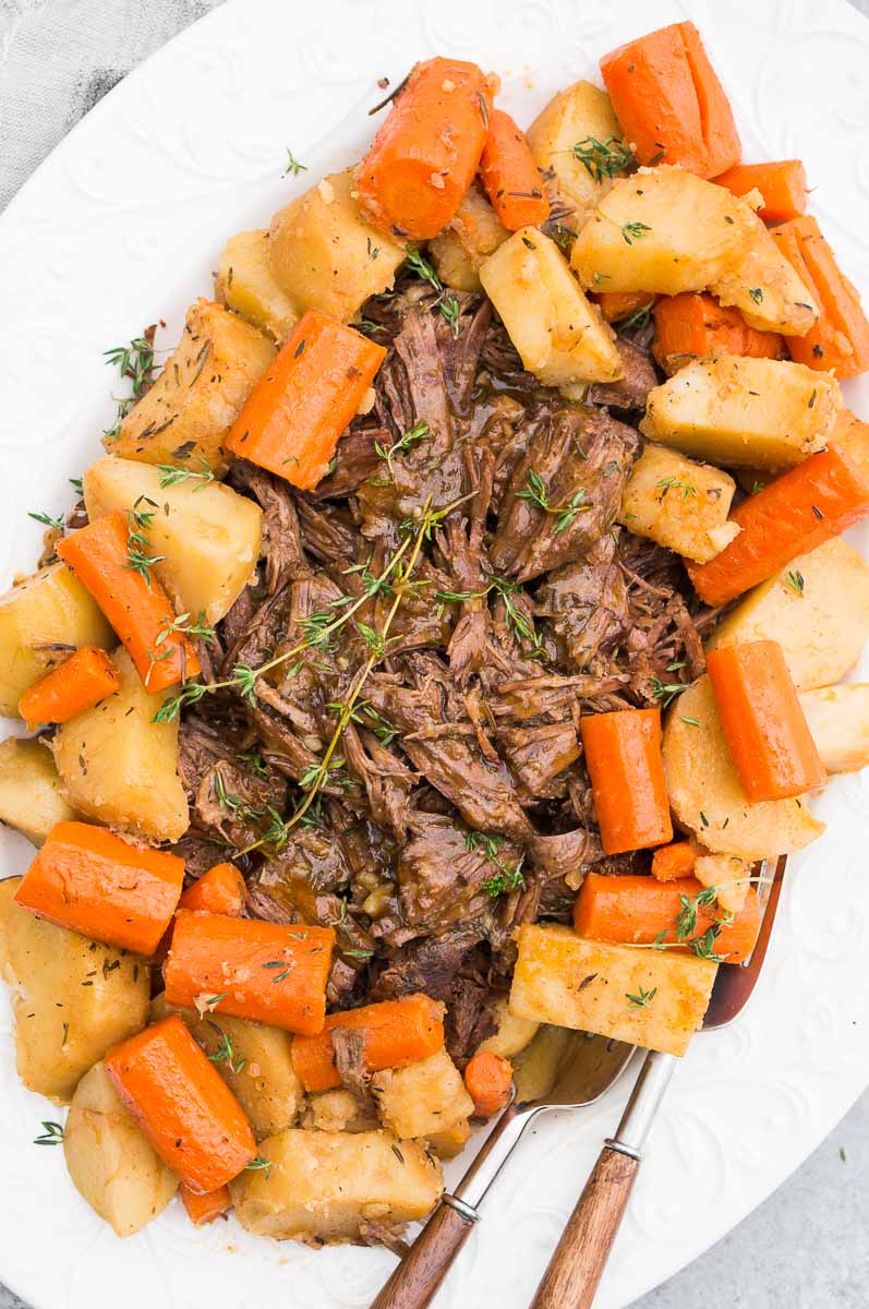 instant pot pot roast with potatoes and carrots served on a white plate