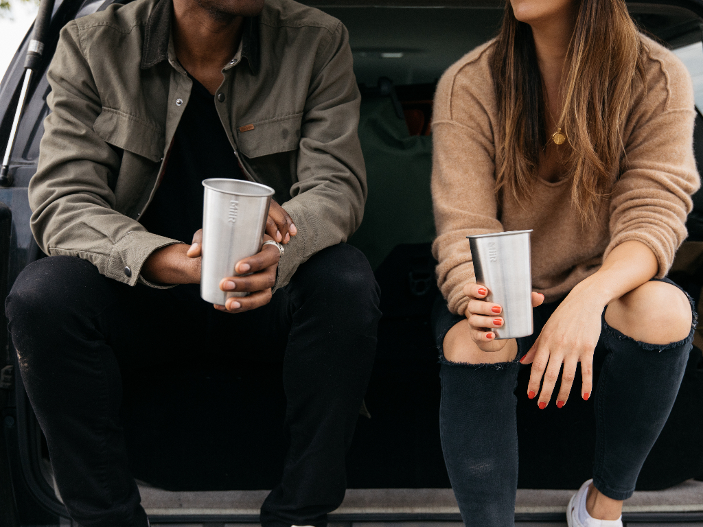 Two people holding 16oz Stainless Steel Pint Cups