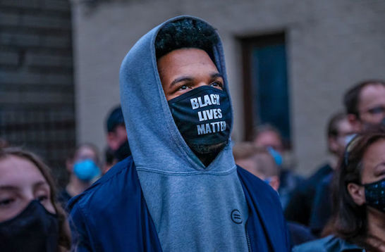 Black man wears a face mask that reads Black Lives Matter