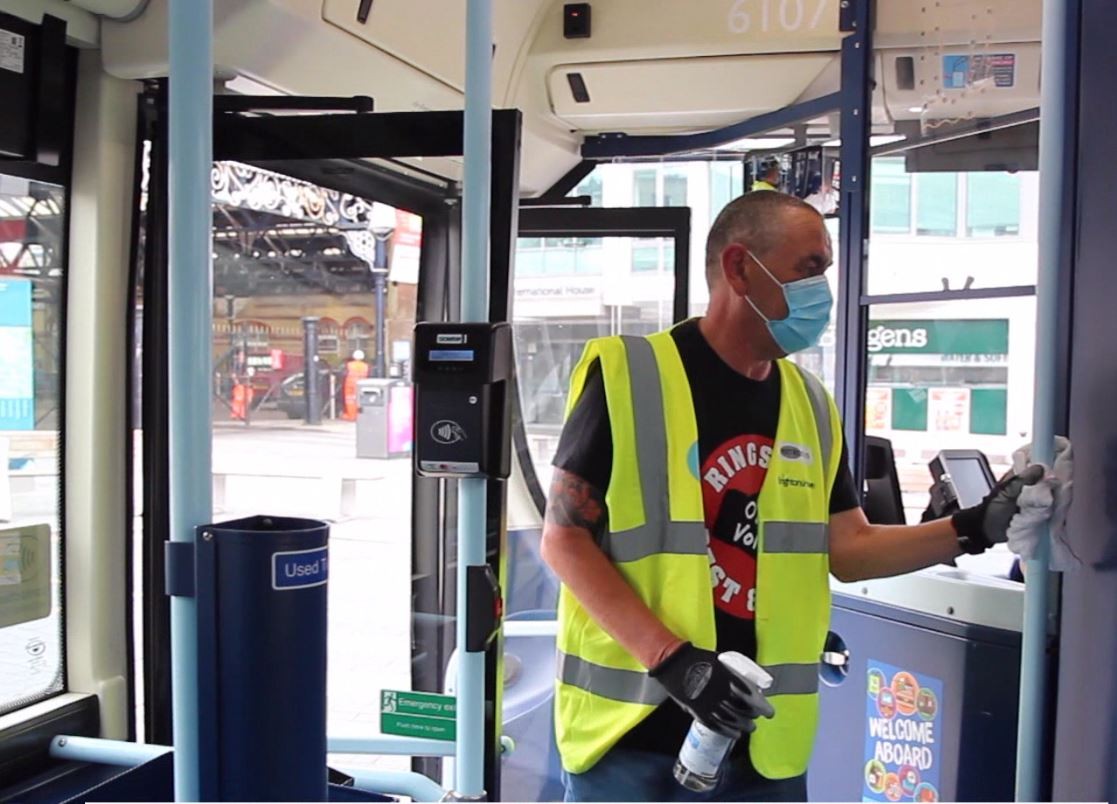 Man cleaning bus hold rails