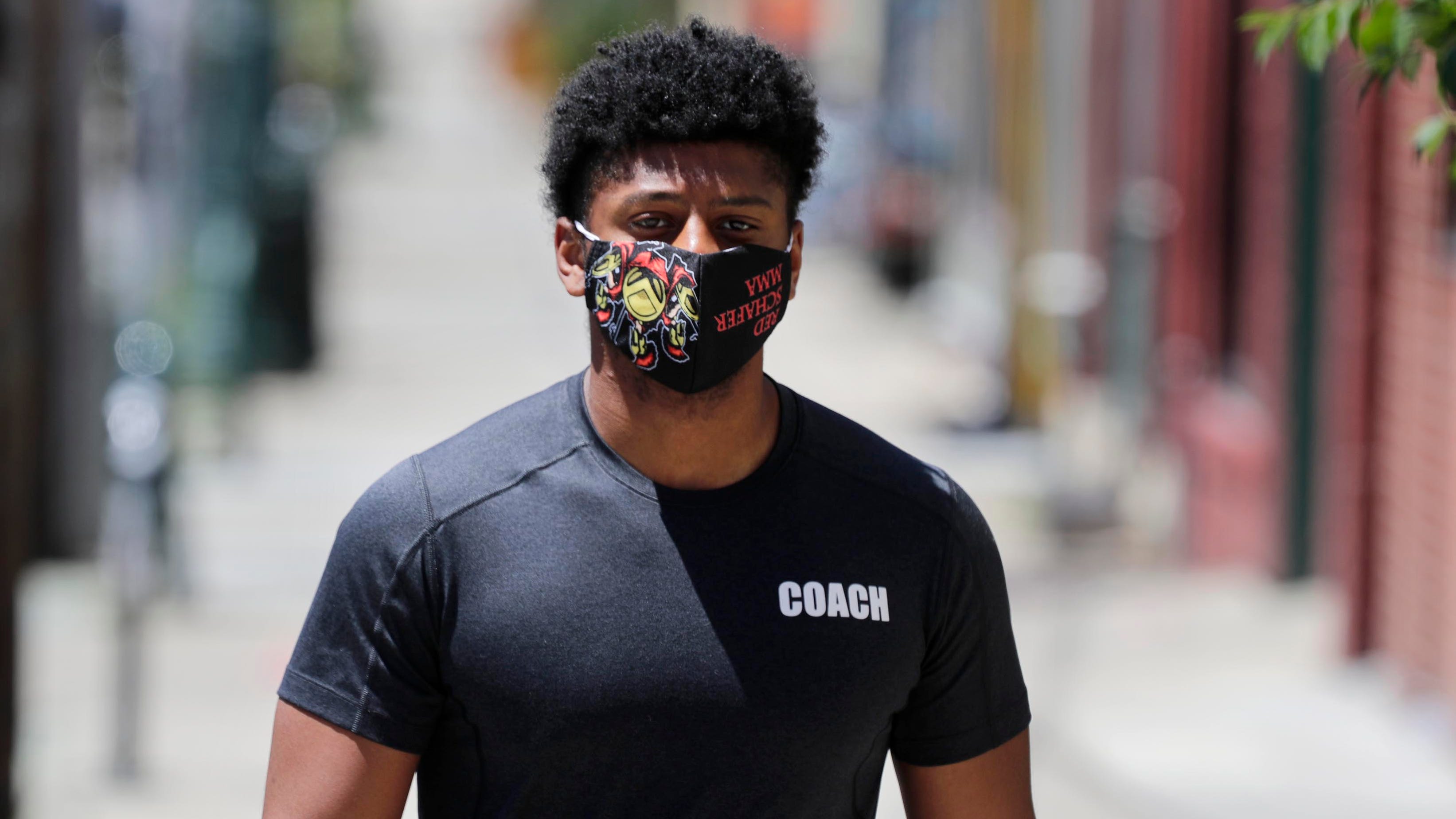 Sharaka Berry wears a mask as he walks on Brady Street on Milwaukee's east side Monday.