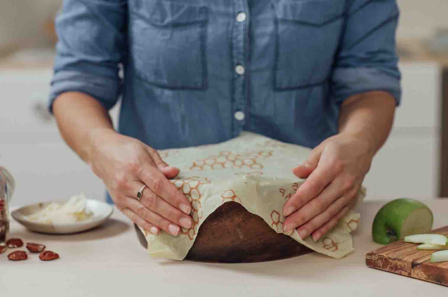 Woman covering casserole dish with bee''s wrap reusable wrap