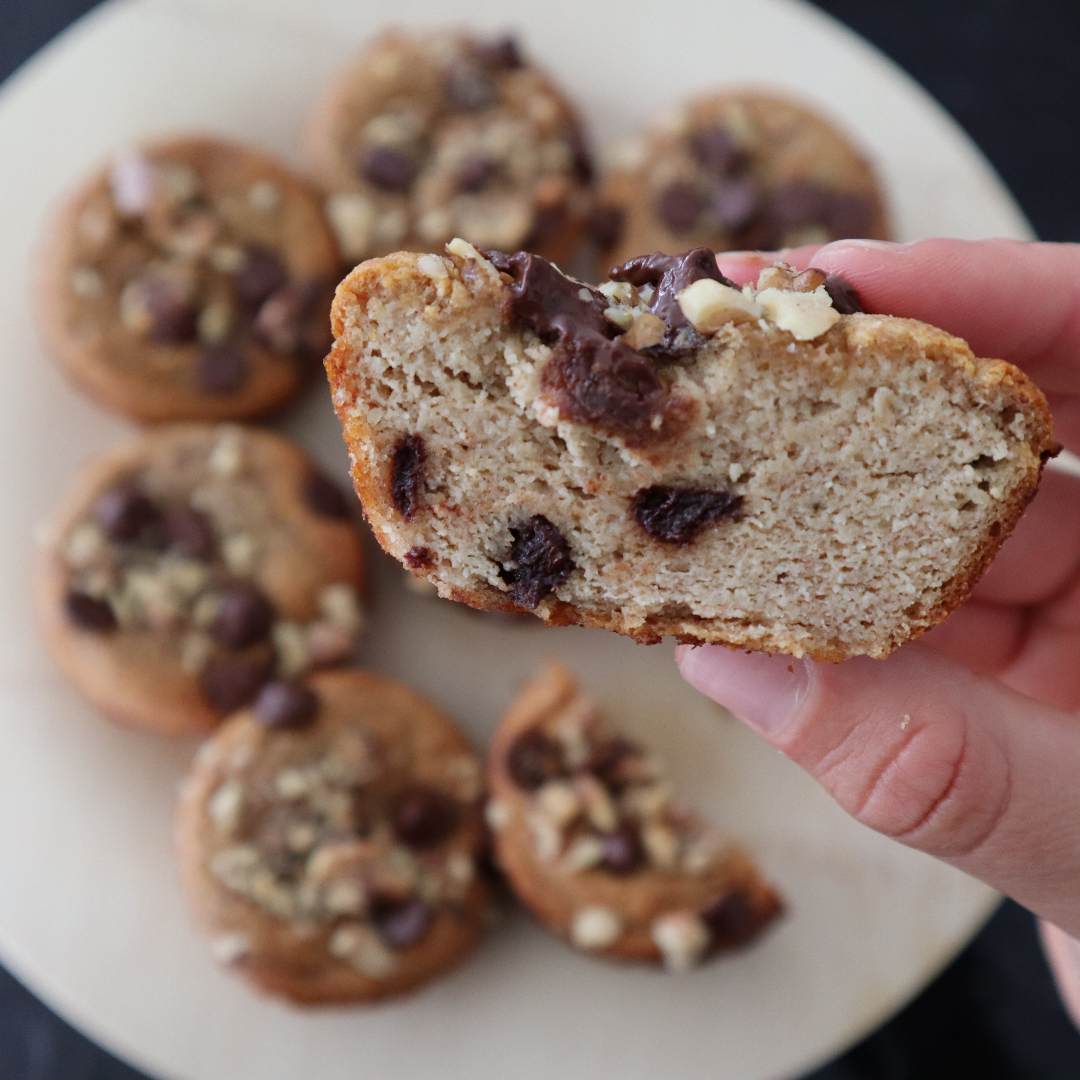 Person holding banana chocolate chip muffins.