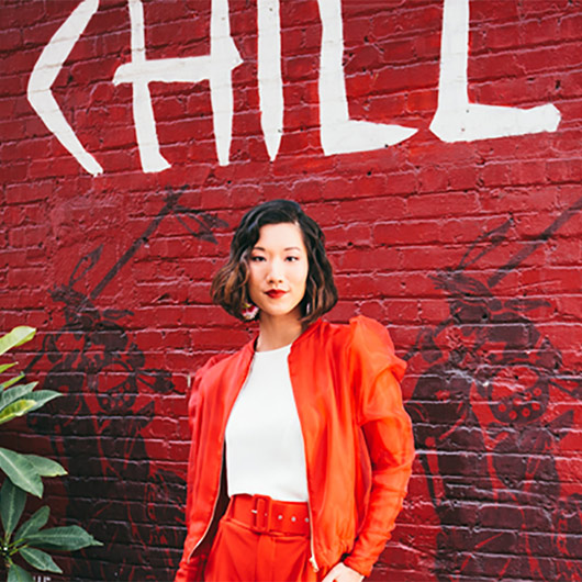 Asian woman against red brick wall
