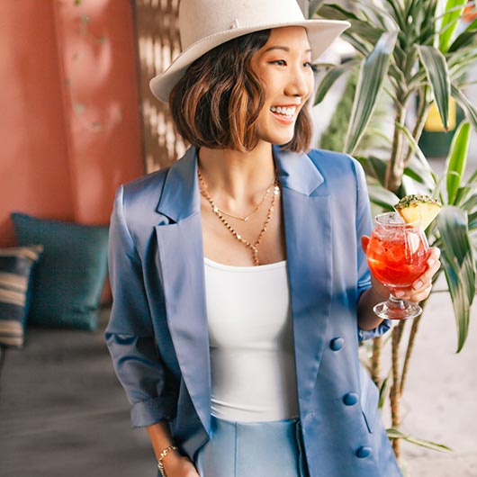 Woman in hat holding cocktail