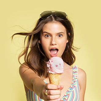 Surprised woman holding out ice cream cone