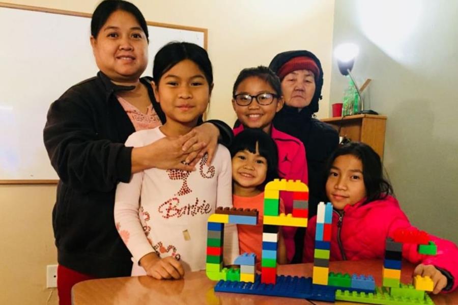 Family of six with a colorful children''s block tower