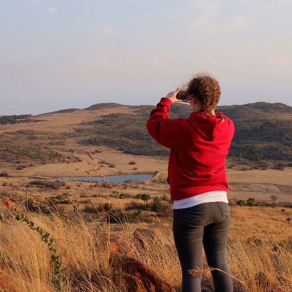 Girl taking a picture across South African plains