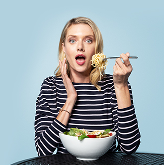 Woman eating big bowl of pasta