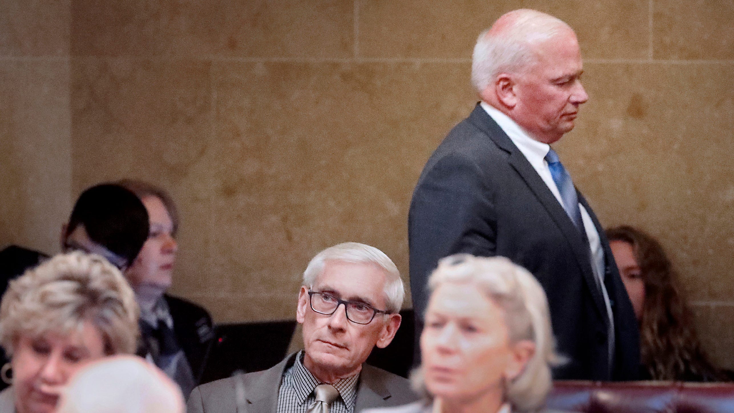 Wisconsin Gov. Tony Evers, seated at center, listens to a Senate debate regarding his pick to head the Department of Agriculture, Trade and Consumer Protection during a session at the Capitol in MadisonTuesday. Walking behind during the proceedings is Senate Majority Leader Scott Fitzgerald, R-Juneau.