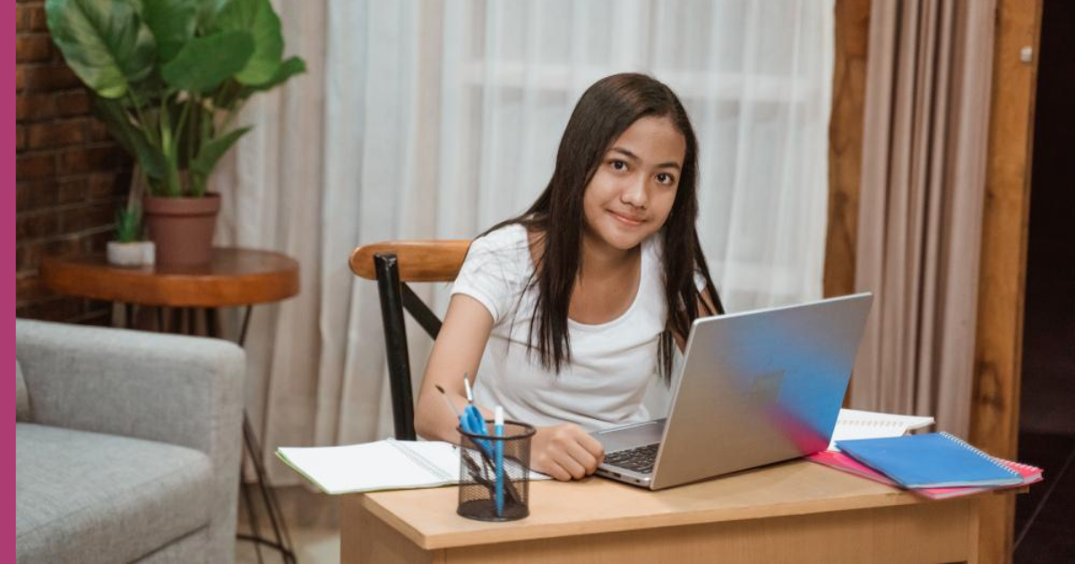 Young girl learning from home at desk with laptop.