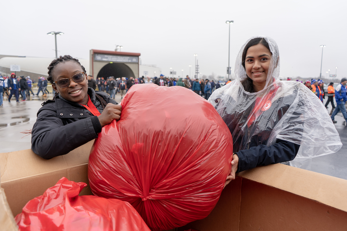 Volunteers donating coats into a box