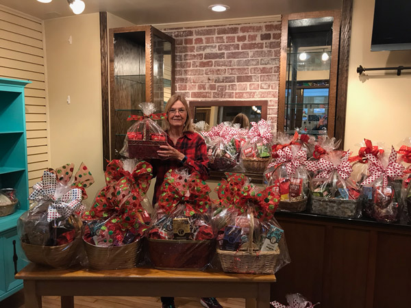 Linda Elliott with a table of created gift baskets ready for pickup