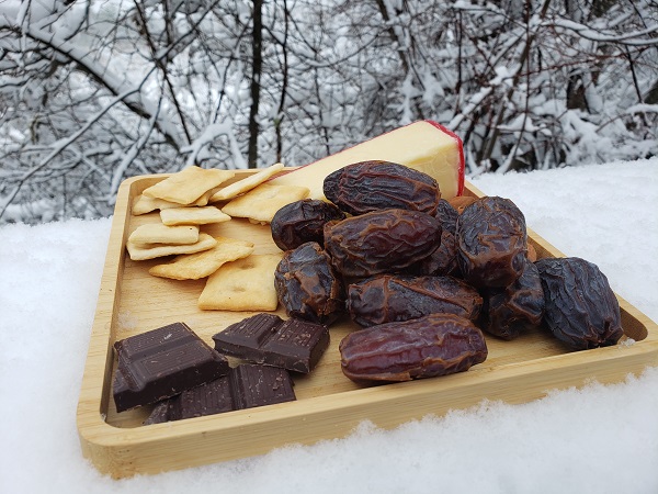 A fancy plate, which includes dates, on a snowy ledge