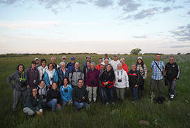 A group of volunteers standing in a field at dusk