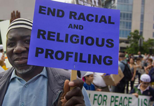 Man holds sign saying end racial and religious profiling 