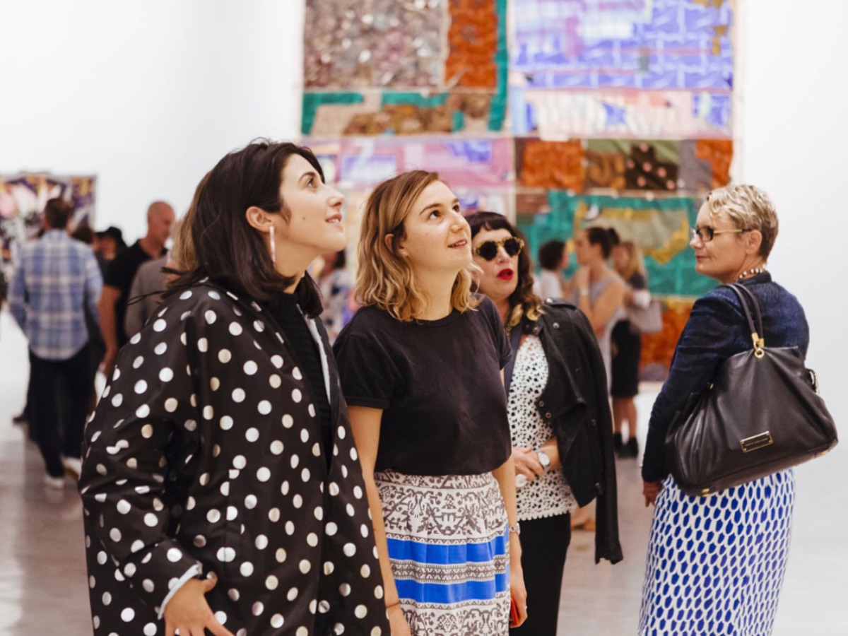 [Two women looking at artwork during exhibition opening]